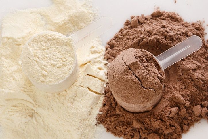 Skopor med vitt och chokladfärgat proteinpulver för träning